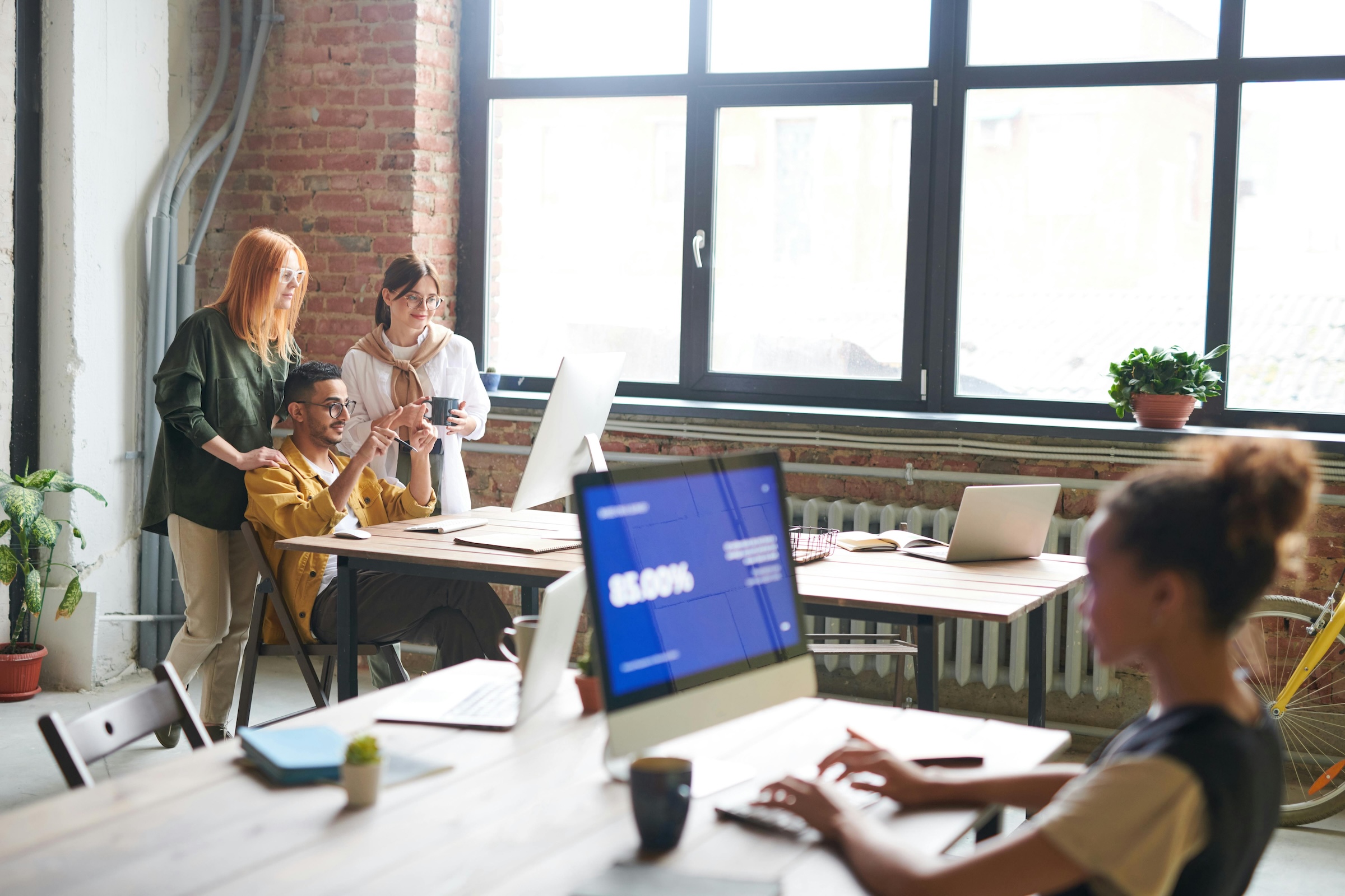 Team collaborating in an open office, dashboard visible on screen