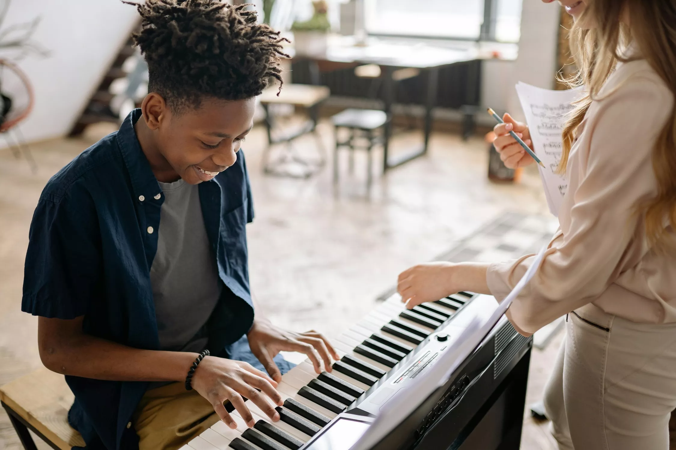 Teacher guiding a student at a keyboard